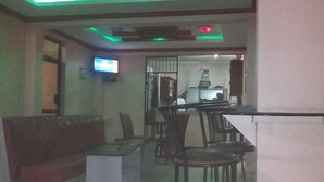 Una sala de estar moderna con un sofá, comedor con sillas y un televisor montado en la pared.