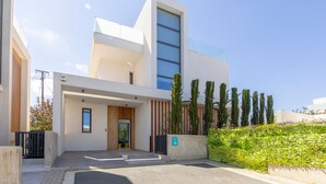 Un bâtiment moderne doté d’une grande fenêtre en verre, d’une porte en bois et d’un mur en béton sur lequel est peint un numéro.