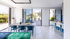 Un comedor moderno con una mesa, sillas y vistas del patio exterior.
