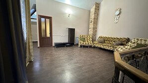 Un salon spacieux avec un canapé, un téléviseur et une cheminée.