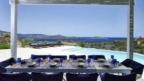 Een terras met uitzicht op zee en heuvels.