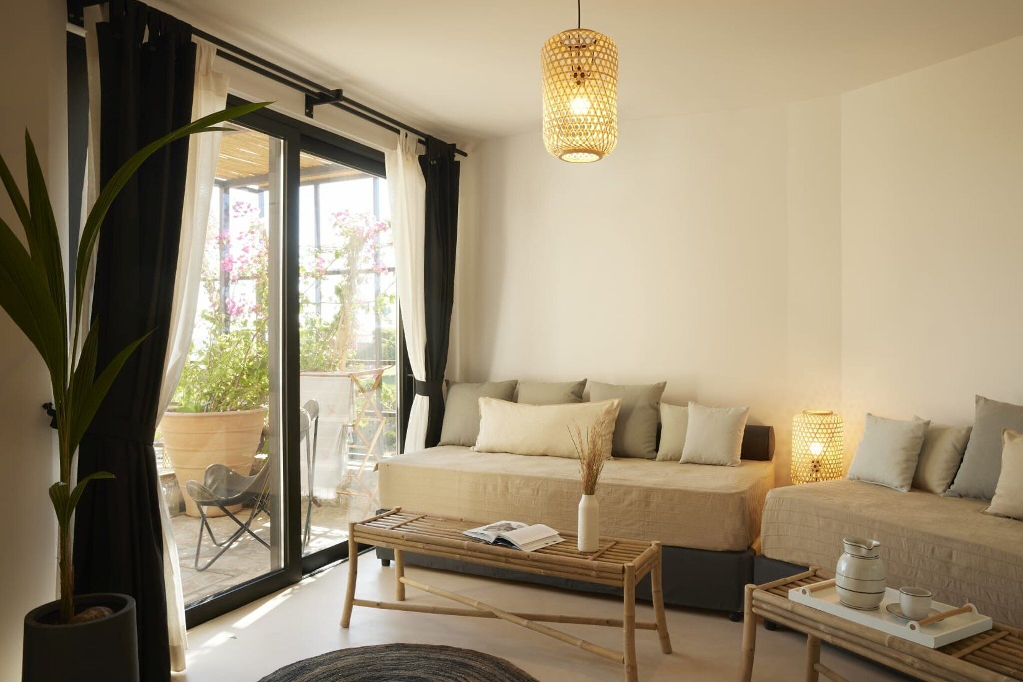 A modern living room with a sofa set, a coffee table, and a hanging light fixture.