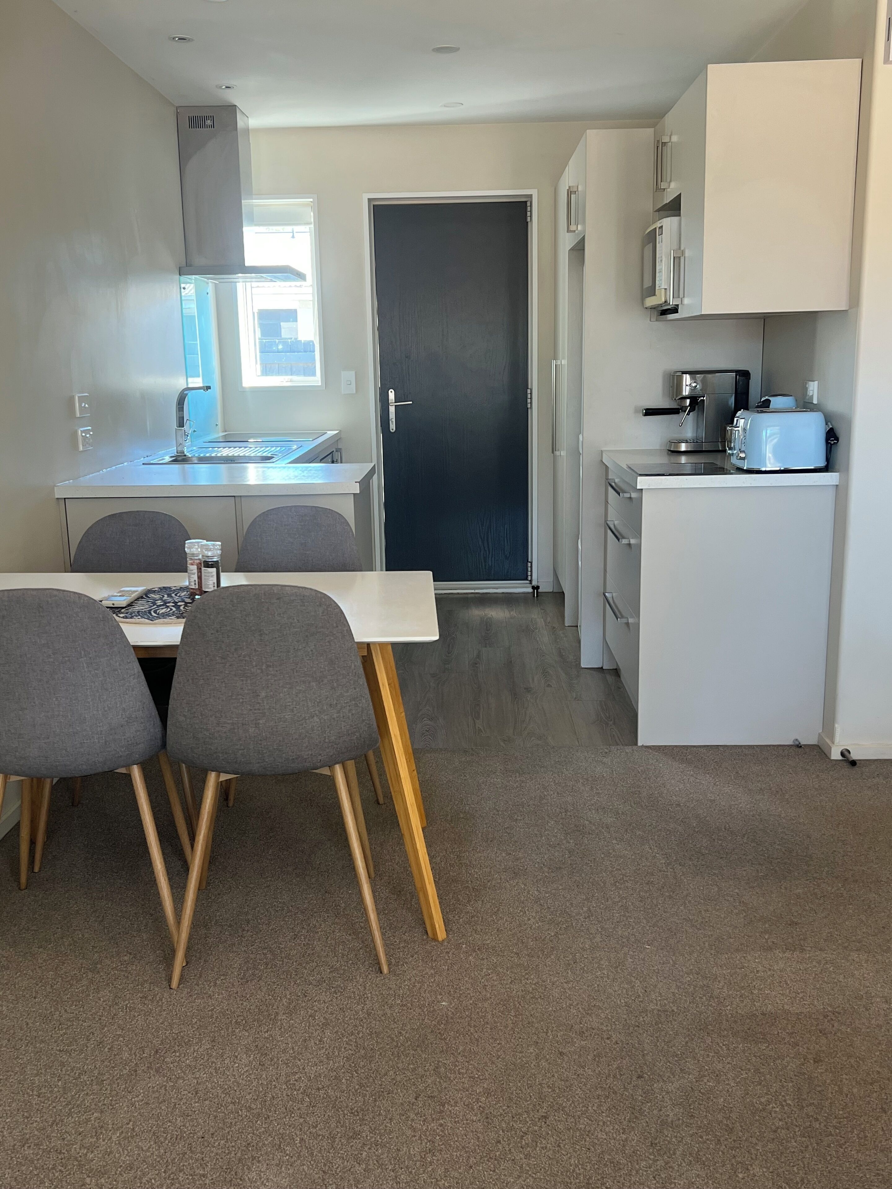 Une cuisine compacte avec un coin repas, comprenant un évier, une cuisinière, un grille-pain et un réfrigérateur.
