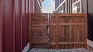 A wooden gate in a narrow alleyway between buildings with vertical siding. - Mt. Princeton Views. Remodeled. Fire Pit & BBQ (Buena Vista)