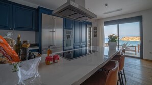 Eine moderne Küche mit blauen Schränken, einer Edelstahl-Dunstabzugshaube und einer großen Kochinsel.