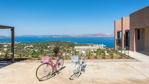 En balkon med to cykler, havudsigt og en bygning med et moderne design.
