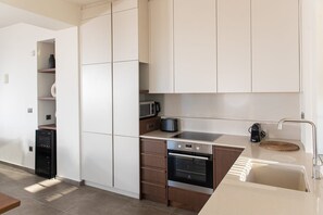A modern kitchen with white cabinets, a microwave, a stove, and a sink. - Villa Eirenis, Divine Sea Views, Private Infinity Pool, Furnished Terrace,. (Crete)