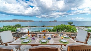 An outdoor dining area with a table set for breakfast overlooking a pool and the sea. - Seafront Villa Solaryth, Divine Sea Views, Private Pool, Furnished Terrace,. (Crete)