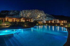 Ett lyxigt hotell med en swimmingpool, en vacker bergsutsikt och väl upplysta utomhusområden.