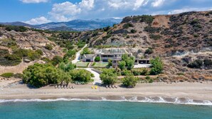 Une propriété située sur la côte, dotée d’une maison moderne, d’une plage privée et offrant une vue sur les montagnes.