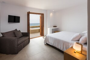 A bedroom with a bed, a sofa, a TV, and a view of the beach. - Villa Terrissa, Divine Sea Views, Private Pool, Furnished Terrace, Arvi (Crete)