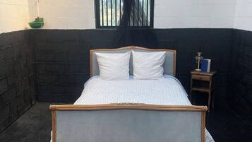 A room with a bed, a window, and a nightstand.