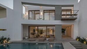 A modern two-story house with a pool, large glass windows, and a balcony. - Seafront Villa Noctessa, Divine Sea Views, Private Infinity Pool, Furnished. (Crete)
