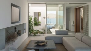 A modern living room with a stone table, grey sofa, and a view of the outdoors. - Seafront Villa Noctessa, Divine Sea Views, Private Infinity Pool, Furnished. (Crete)