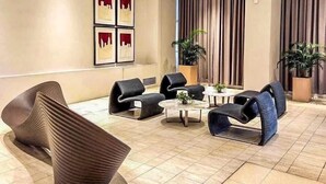 A modern lounge area with a round coffee table, several lounge chairs, and a large window with curtains. - New! Comfortable 2BR in Central BGC w/ Fast WiFi (G3W2+RG Taguig, Metro Manila, Philippines)