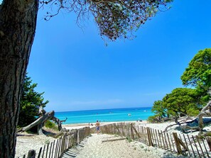 A beach with a wooden fence, clear blue sky, and ocean view. - Top floor, 3 double bedrooms, rooftop terrace, fantastic views of the sea, mountains, and village (Santa-Reparata-di-Balagna)