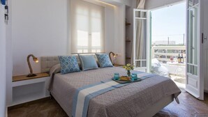 A bedroom with a bed, bedside lamps, a window, and a balcony with a table and chairs. - Villa Elatheia, Prvate Pool and Garden, Furnished Terrace, BBQ facilities, Naxos (Naxos)