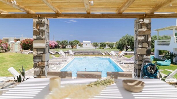 A pool area with stone pillars, lounge chairs, and a clear view of the surrounding landscape. - Villa Elatheia, Prvate Pool and Garden, Furnished Terrace, BBQ facilities, Naxos (Naxos)