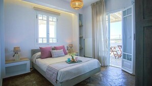 A bedroom with a bed, bedside lamps, a window, and a view of the outside. - Villa Elatheia, Prvate Pool and Garden, Furnished Terrace, BBQ facilities, Naxos (Naxos)