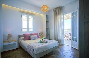 A bedroom with a bed, bedside lamps, a window, and a view of the outside. - Villa Elatheia, Prvate Pool and Garden, Furnished Terrace, BBQ facilities, Naxos (Naxos)