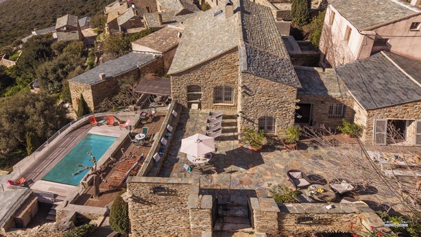 Ein Steinhaus mit Swimmingpool, Außenbereich und einer Steintreppe.