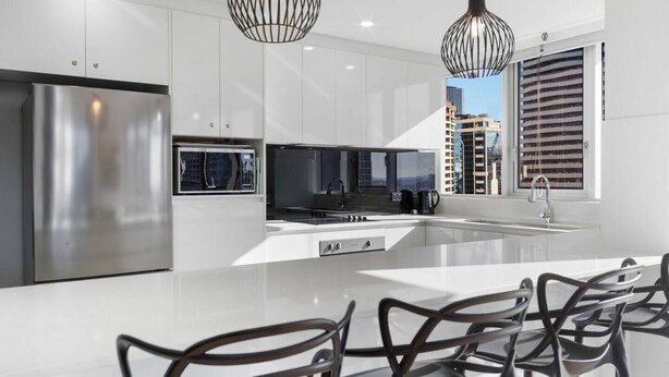 A modern kitchen with stainless steel appliances, a central island, and a view of tall buildings. - Beach Haven Getaway Broadbeach - WiFi, Parking (Broadbeach)