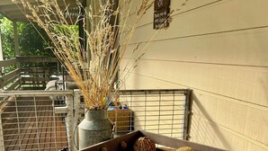 A wooden table with a magazine, a vase with dried plants, and a cow figurine. - Berry Lodge- A Sweet Country Escape! (Jamieson)