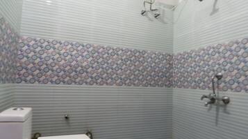 Een douche, handdoeken, zeep, toiletpapier