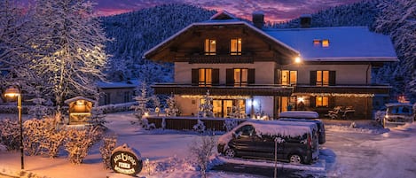 Una cabaña nevada con un letrero que indica que es una posada de correos.