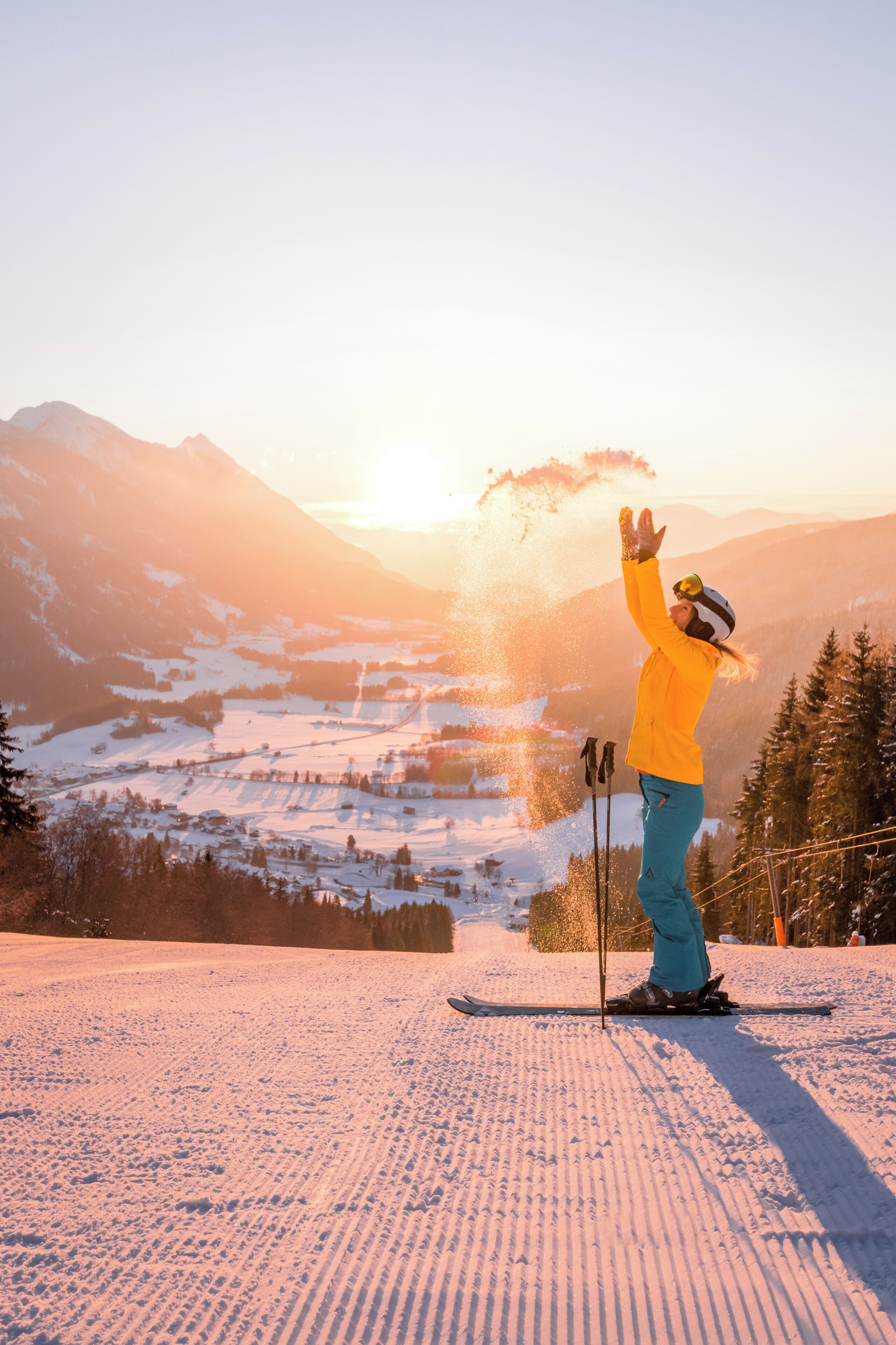 A person skiing on a snowy slope with a mountainous backdrop.