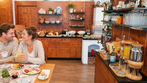 A breakfast setting with a coffee machine, fruit, and pastries on the counter. - Ferienhof Alte Post (Gitschtal)