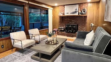 A modern living room with a fireplace, two armchairs, a sofa, and a coffee table.