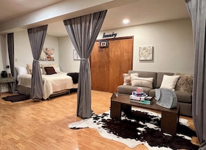 Un salon moderne comprenant un lit, un canapé, une table basse et un tapis en peau de vache.