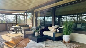 A modern outdoor living space with a sofa, chairs, and a dining area.