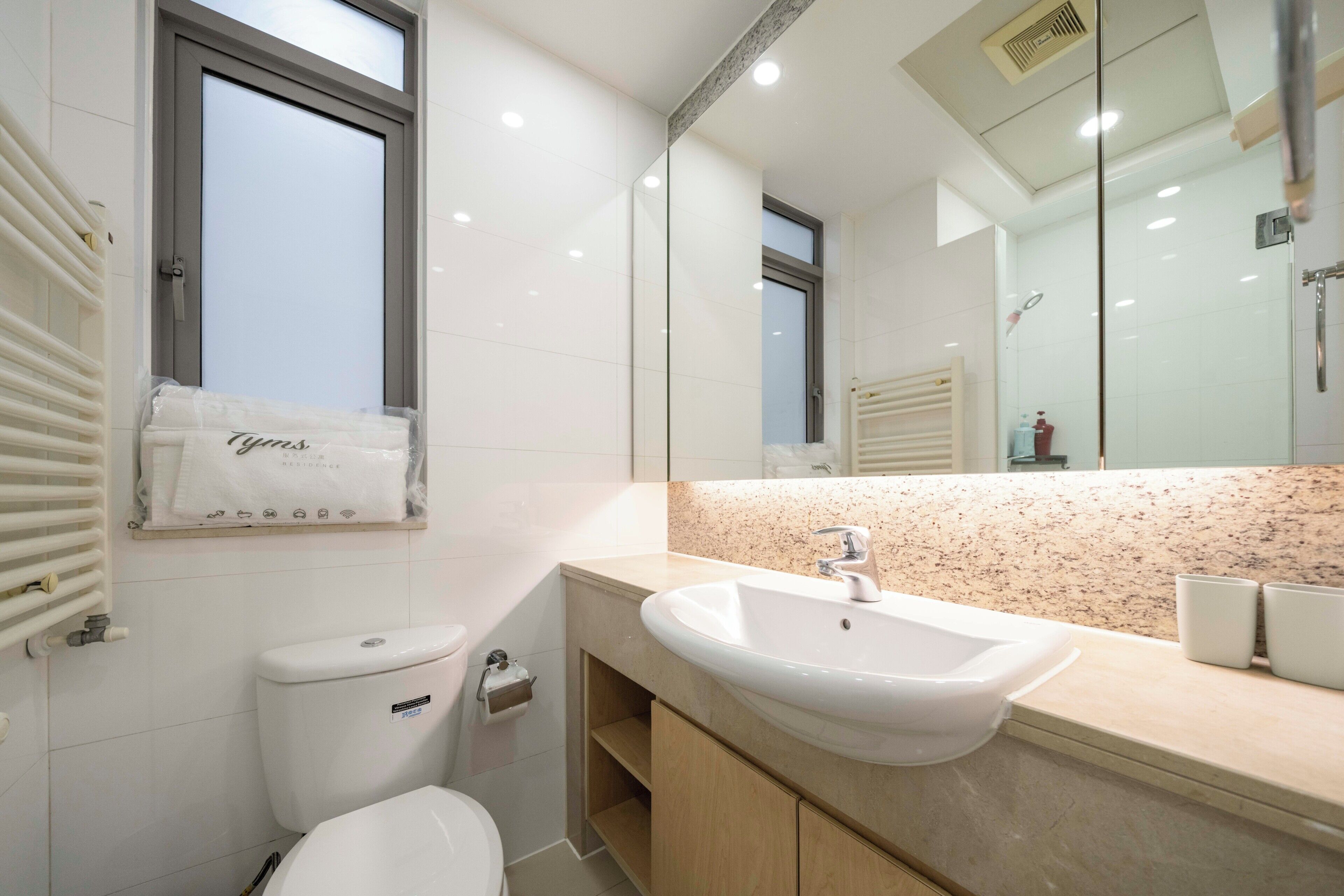 A modern bathroom with a toilet, sink, and mirror.