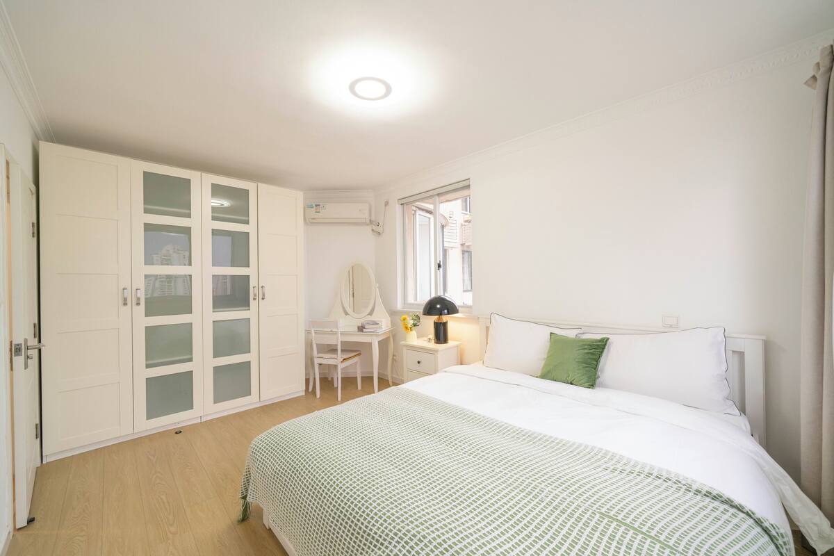 Un dormitorio con cama, escritorio, silla y armario.
