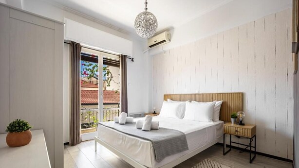 A modern bedroom with a bed, bedside table, and a view of the outside. - Athens Nala (Athens)