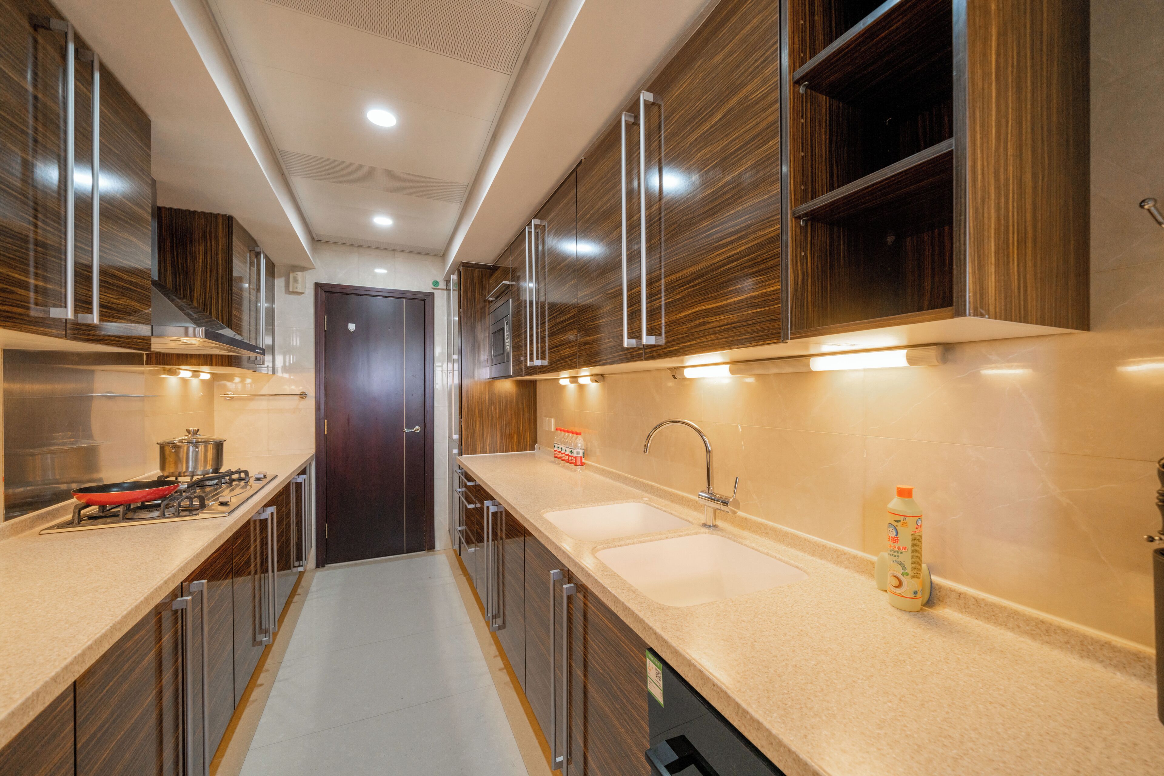 A modern kitchen with a stove, sink, and cabinets.