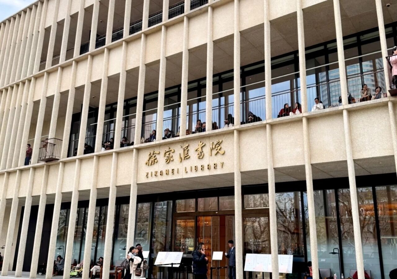 A building with a grid-like facade and a sign reading 'ZIZANELI LIBRARY'.