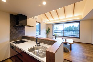 Una cocina moderna con una isla grande, estufa integrada y ventana con vistas al exterior.