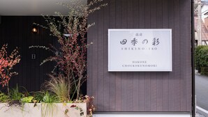 Een gebouw met een bord waarop de namen "SHIKINO-IRO" en "HAKONE CHOUKUNOMORI" staan.