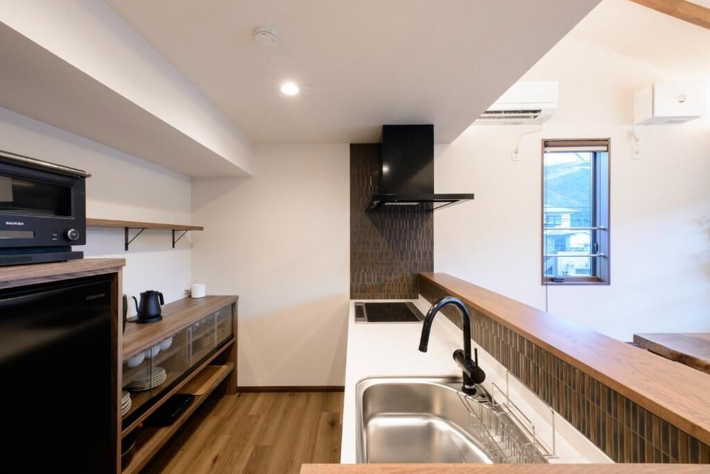 Una cucina moderna con forno a microonde, piano cottura e lavello.
