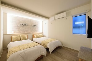 Ein Schlafzimmer mit zwei Betten, einem großen Fenster und einer Wand-Klimaanlage.