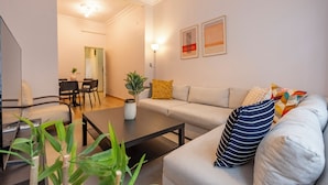 A modern living room with a sofa, coffee table, and a dining area with chairs and a table. - Spacious 3-Bedroom, 2-Bathroom Family Apartment in Central Location No Stair (İstanbul)