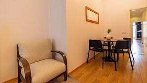 A dining area with a wooden chair, a table, and a vase. - Spacious 3-Bedroom, 2-Bathroom Family Apartment in Central Location No Stair (İstanbul)