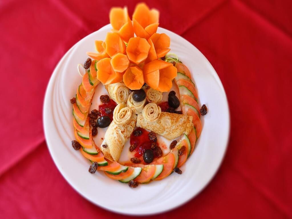 A plate of food with a decorative arrangement of vegetables and fruits.
