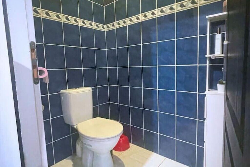 Casa de banho com sanita, lavatório e zona de duche.