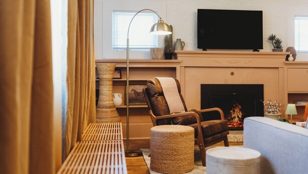 Una sala de estar con chimenea, televisor y sofá.