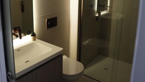 A modern bathroom with a glass shower enclosure, a white sink, and a toilet. - 1st Floor Luxury 2-bed Apt, Sleeps 6 (St. Andrews)
