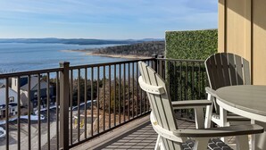 A balcony with a view of a lake and distant mountains. There is a table and two chairs. - Heavenly Pointe | Penthouse Lake Views, Elevator, Accessible, King Beds (Branson)